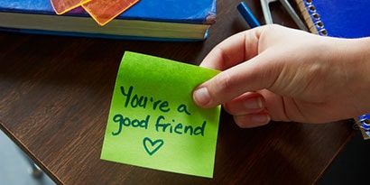 Student writes a nice thought or a thank you on the Post-it® Notes